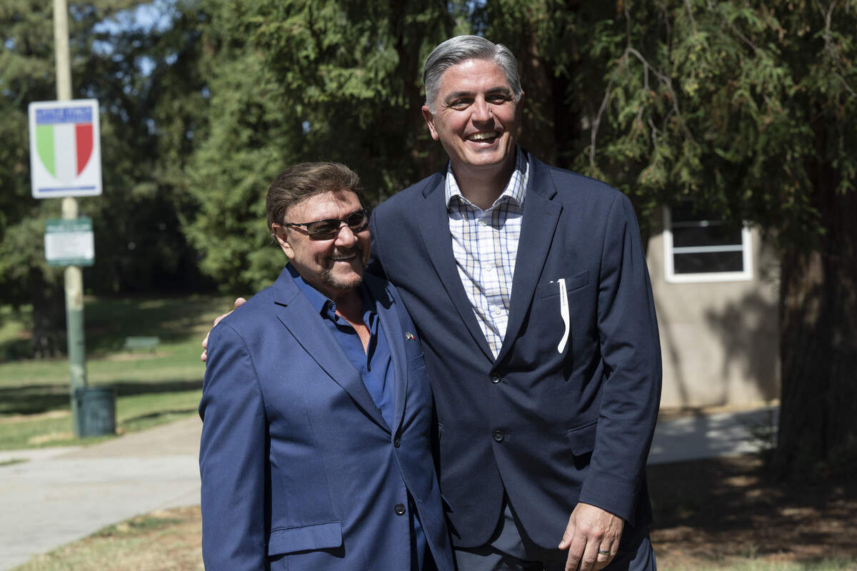 Italian Cultural Society of Sacramento President Bill Cerrutti and City Councilmember Phil Pluckebaum embrace during an event hanging new signs designating the Little Italy Historic District in East Sacramento on Monday, Aug. 10, 2026.